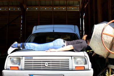 Planking auf einem Auto und der kopf im Betonmischer
